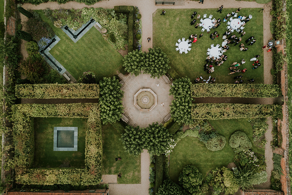 A bird’s eye view of the gardens at Braxted Park with guests enjoying champagne and canapes outdoors